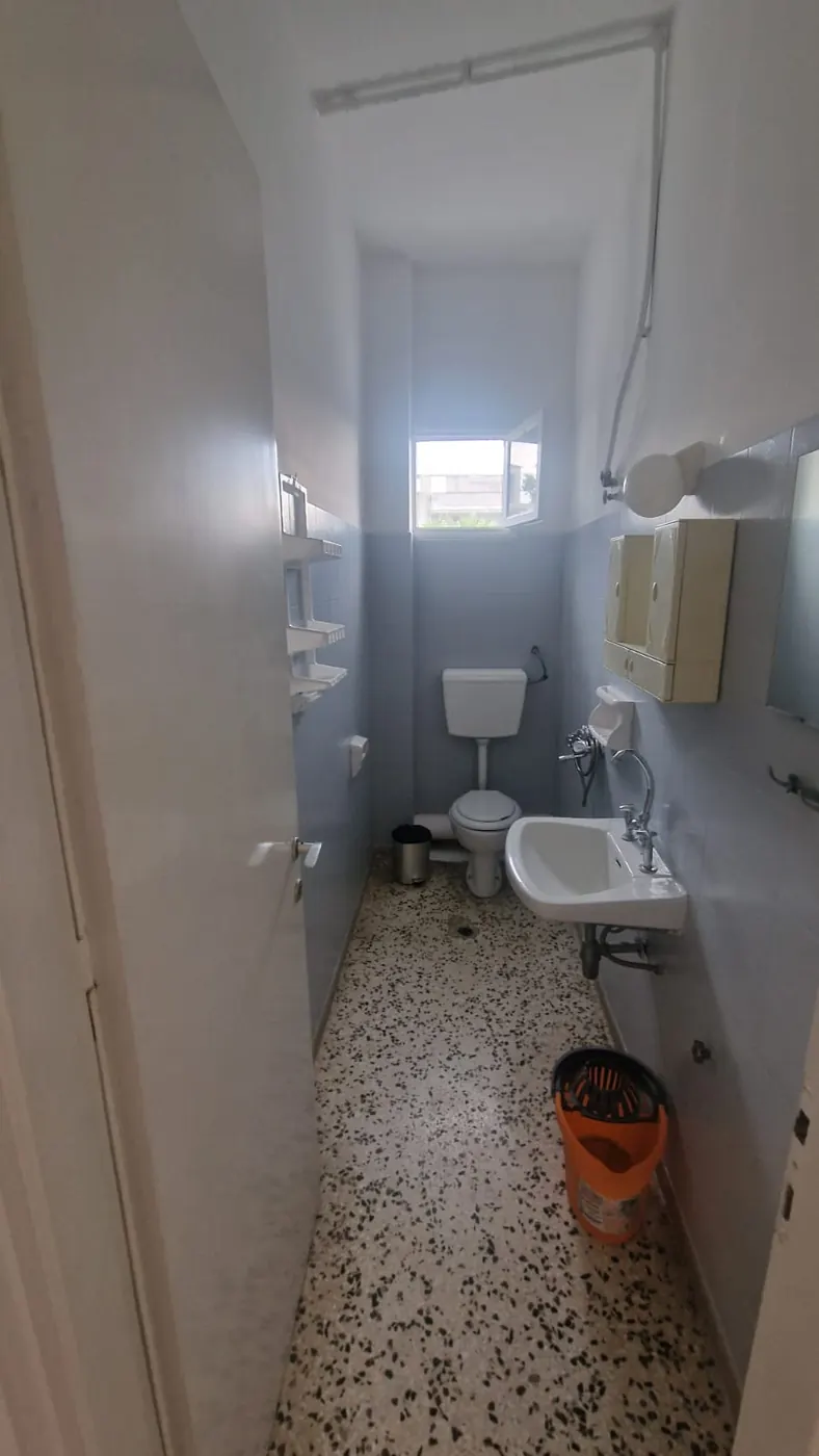 Odvojeno kupatilo Apartmana 1 sa WC šoljom, lavaboom, ogledalom i prozorom