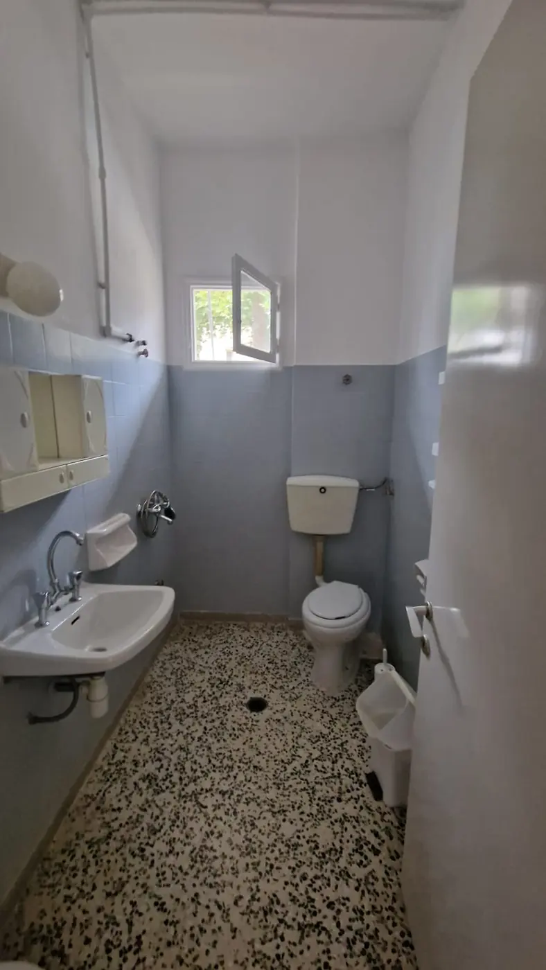 Ξεχωριστό μπάνιο του Διαμερίσματος 2 με WC, νιπτήρα, καθρέφτη και παράθυρο