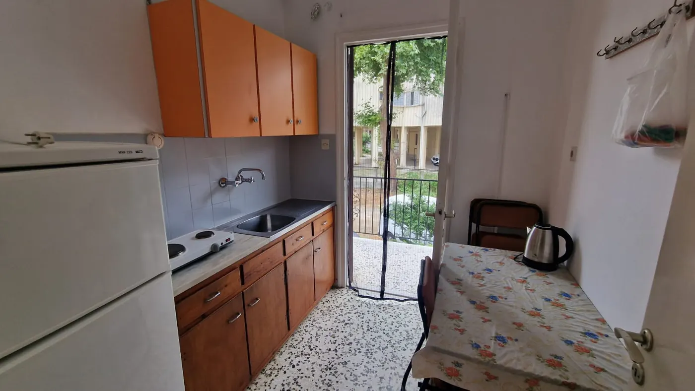 Κουζίνα του Διαμερίσματος 2 με νεροχύτη, εστίες, ψυγείο, ντουλάπια και
                    τραπέζι