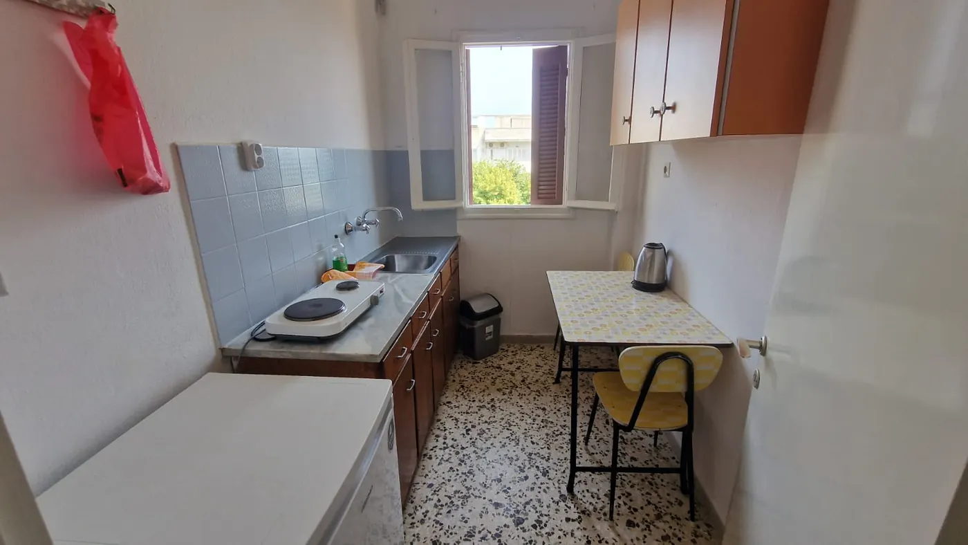 Κουζίνα του Διαμερίσματος 3 με νεροχύτη, εστίες, ψυγείο, ντουλάπια και
                    τραπέζι