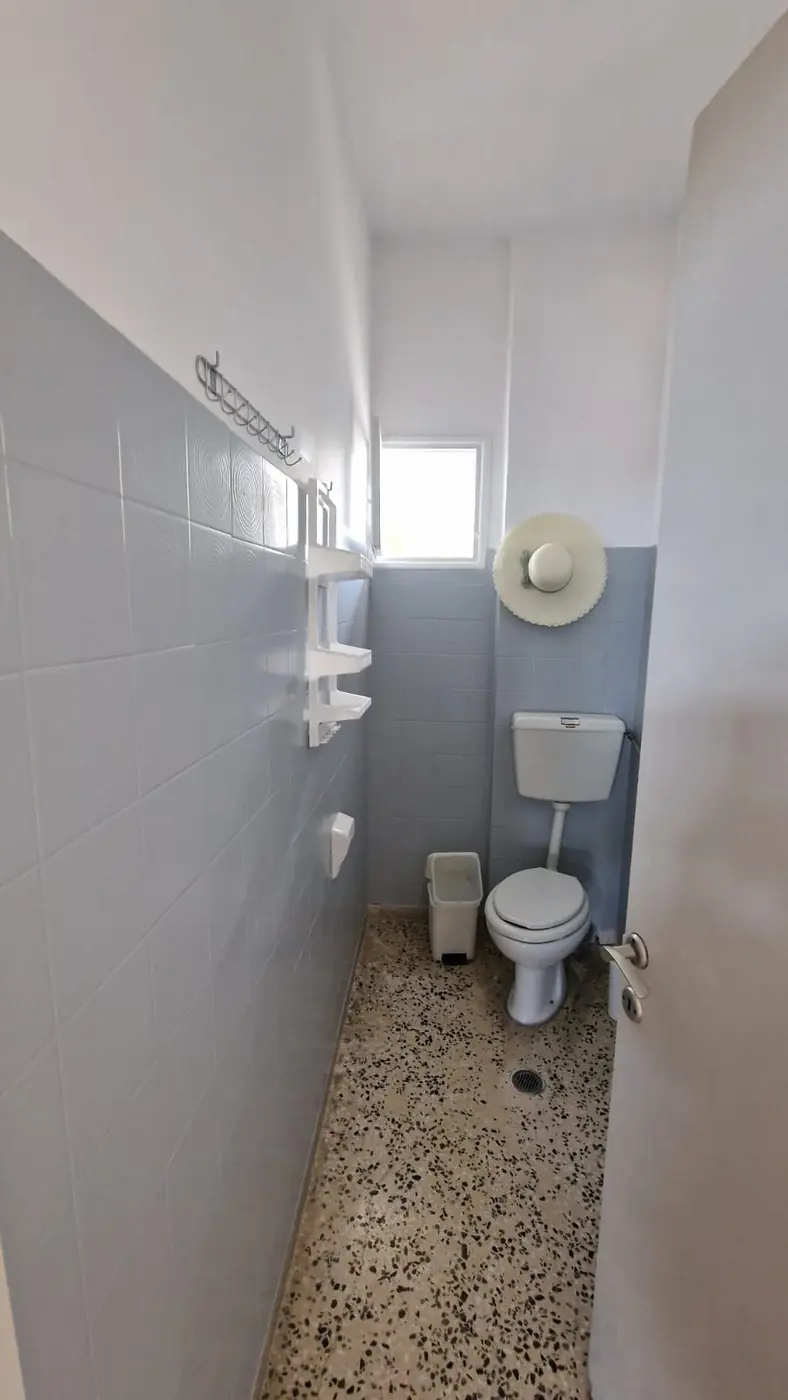 Sopstveno kupatilo Apartmana 4 sa WC-om, policama, kukama i prozorom