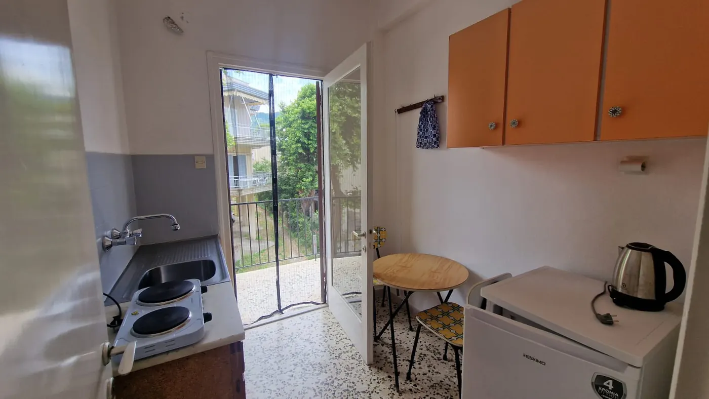Kuhinja Apartmana 4 sa sudoperom, ringlama, frižiderom, visećim elementima i
                    trpezarijskim stolom