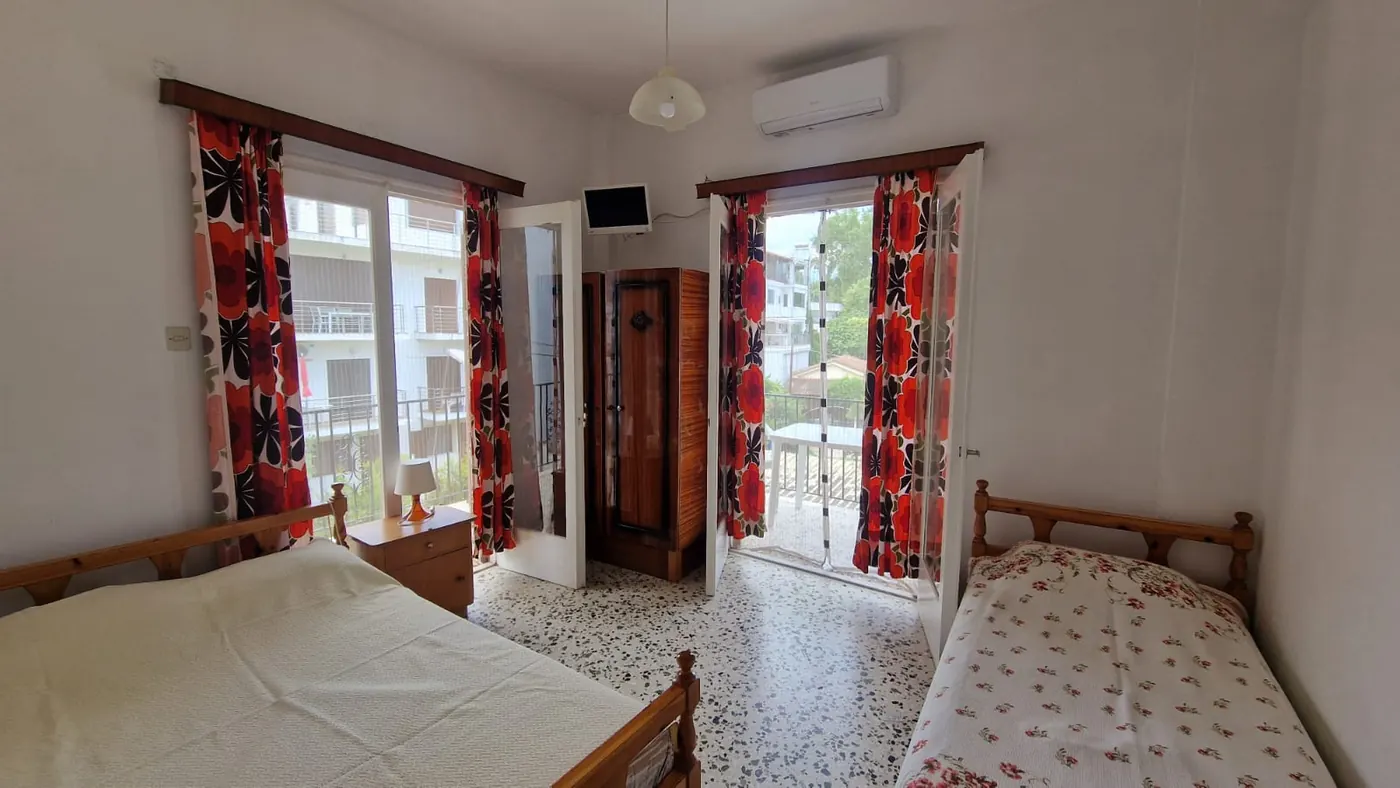 Spavaća soba Apartmana 4 sa bračnim krevetom, jednostrukim krevetom, klima
                    uređajem i dvojim balkonskim vratima