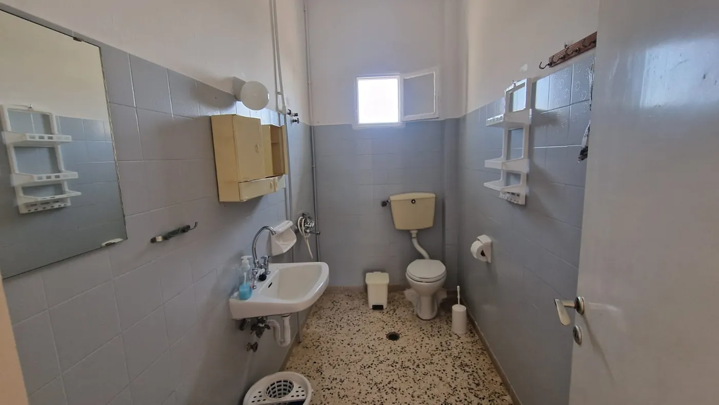 Odvojeno kupatilo Apartmana 5 sa WC šoljom, lavaboom, velikim ogledalom i
                    prozorom