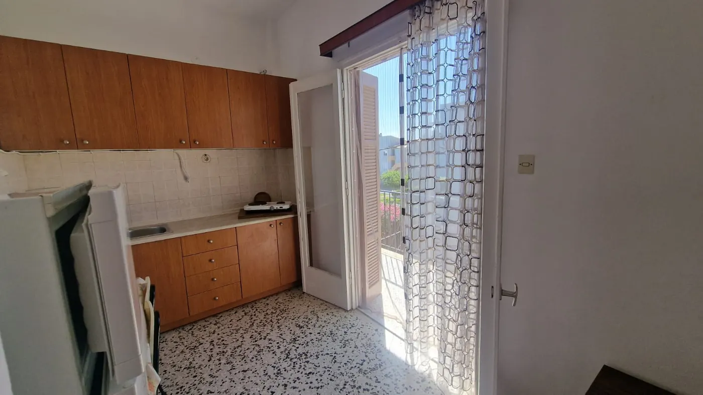 Kuhinja Apartmana 5 sa sudoperom, ringlom, frižiderom i vratima ka
                    balkonu