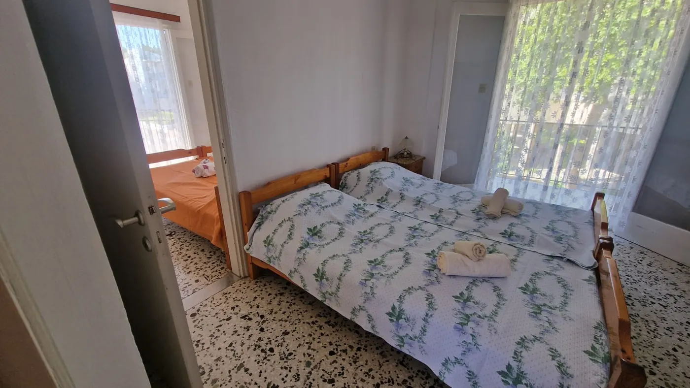 Druga spavaća soba Apartmana 5 sa dva jednostruka kreveta, noćnim
                    stočićem i prozorom ka zelenilu