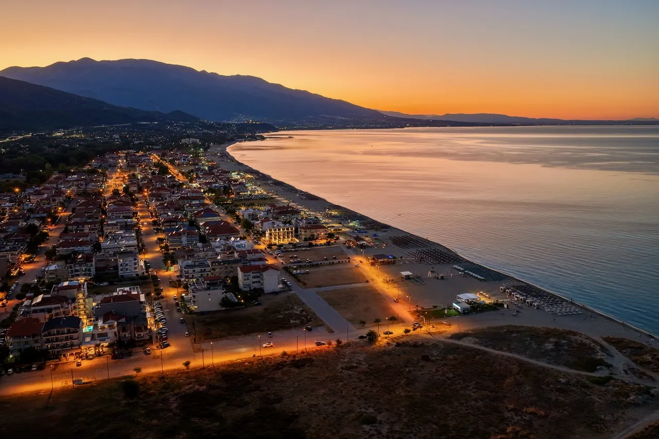 Promenade und Tavernen in Neoi Poroi: beleuchtete Stra&szlig;en am Strand
                nach Sonnenuntergang