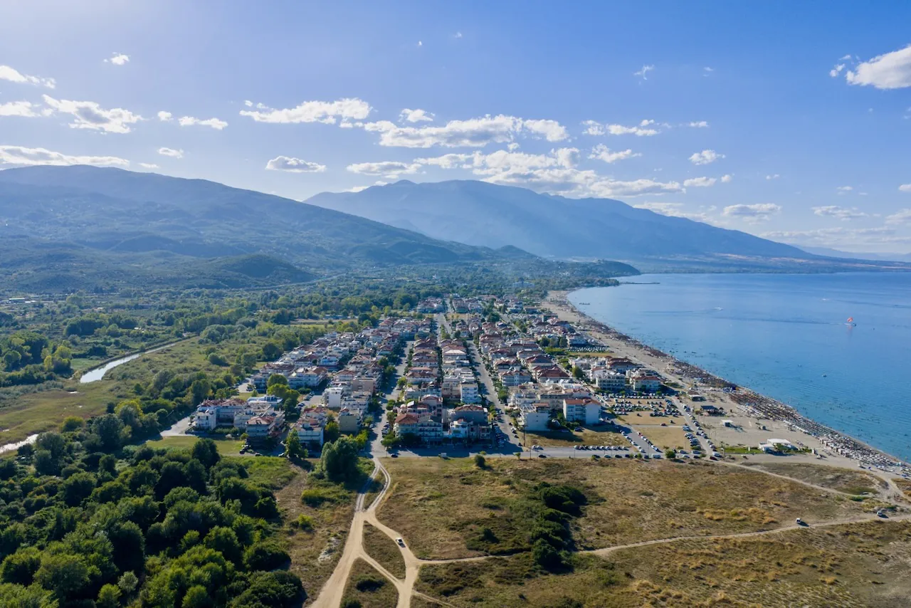 Nei Pori Strand s&uuml;dlich von Platamonas: Luftaufnahme des Ortes am breiten
                Sandstrand vor den bewaldeten H&auml;ngen des Olymp