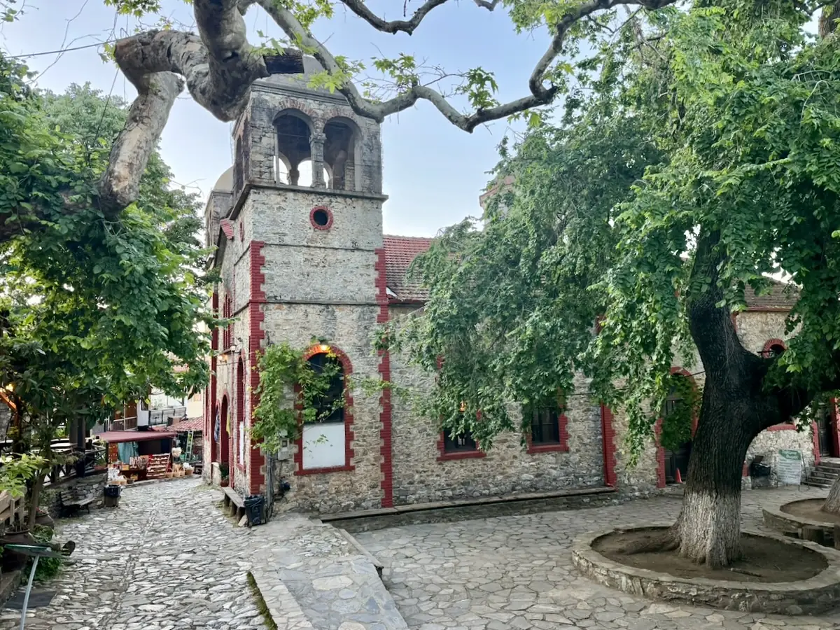The church of Agios Panteleimon on the village square of Palaios Panteleimonas,
                surrounded by old plane trees